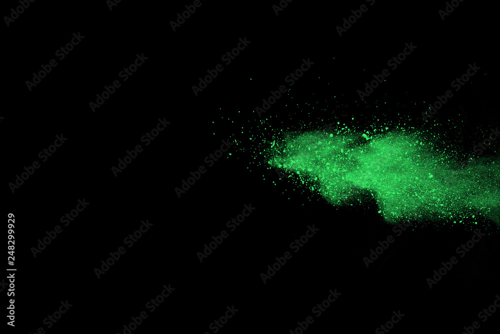 Fototapeta premium The movement of abstract dust explosion frozen green on black background. Stop the movement of powdered green on black background. Explosive powder green on black background.
