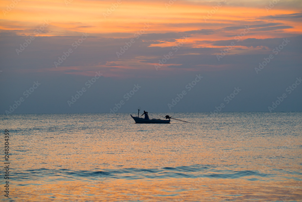 Fisherman on a boat in the Gulf of Siam at sunset background. Thailand