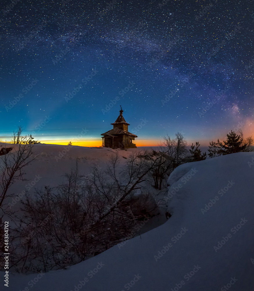 Winter night on Lake Ladoga. Church on the island. Old wooden architecture.