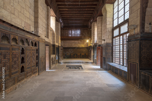 Hall at ottoman era historic house of Moustafa Gaafar Al Seleehdar located at Al Darb Al Asfar District  Cairo  Egypt with decorated wooden ceiling  marble decorated floor and ornate stone walls