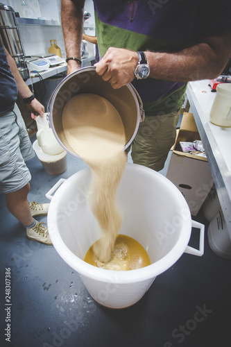 Brewers mixing up yeast in a brewery