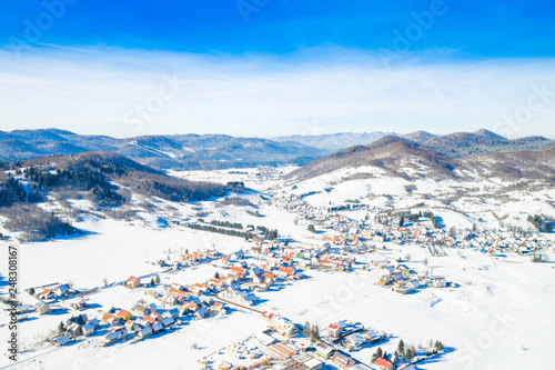     Croatian countryside landscape in winter, panoramic view of small town of Mrkopalj under snow in Gorski kotar, mountains in background  photo