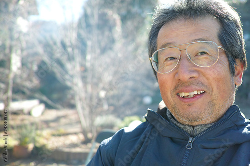 A handsome elder Asian man smiling into the camera