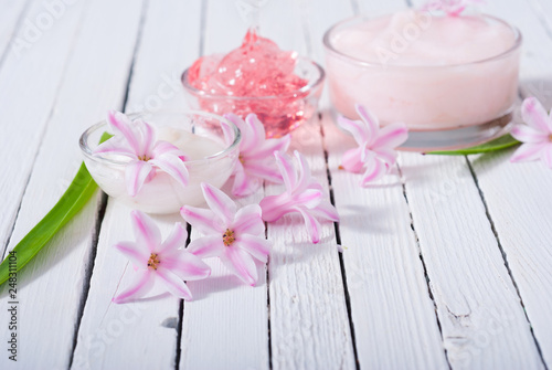 beauty products with hyacinth flowers on white wood