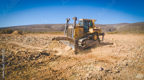 Aerial image of a bulldozer pushing and ripping ground on an agricultural piece of land