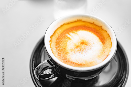 Delicious espresso coffee in a dark cup on the table.