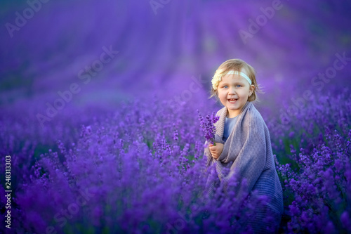 Cute baby in the flowering field of lavender.