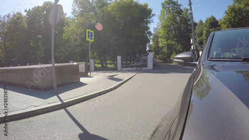 Car moves along the city street on sunny summer day. Front view from the car body.