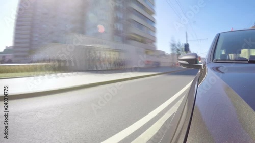 Time lapse of car moves along the city street on sunny summer day. Front view from the car body.