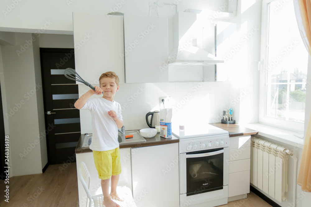 Sweet preschool child in the kitchen, making pancakes in the morning Sweet preschool child in the kitchen, making pancakes in the morning