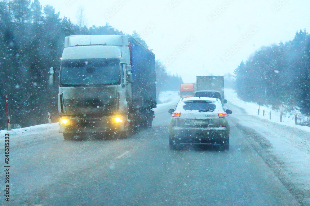 Snowstorm on the highway. Cars on the road with snow. View from the car window. Background.