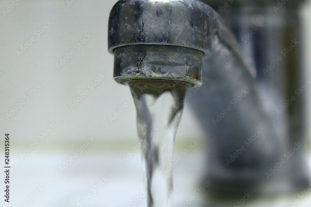 Bathroom faucet. Water flows from the tap. Close-up. Background. Bathroom faucet. Water flows from the tap. Close-up. Background.