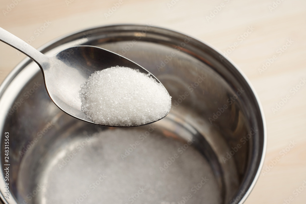 Adding sugar to the bowl. Cooking dishes with sugar Adding sugar to the bowl. Cooking dishes with sugar