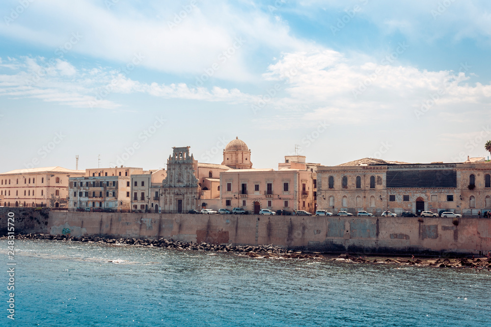 Old buildings in seafront of Ortygia (Ortigia) Island, Syracuse, traditional architecture of Sicily, Italy.