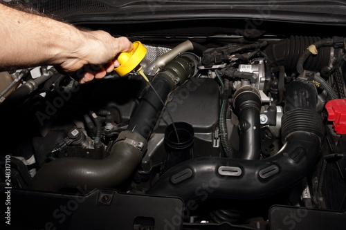 Meccanico a lavoro su di una automobile moderna per il controllo livello olio motore