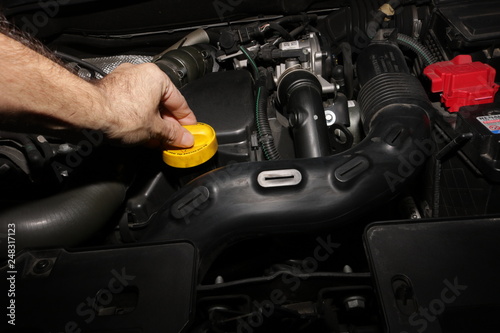 Meccanico controllo olio motore auto in officina riparazione