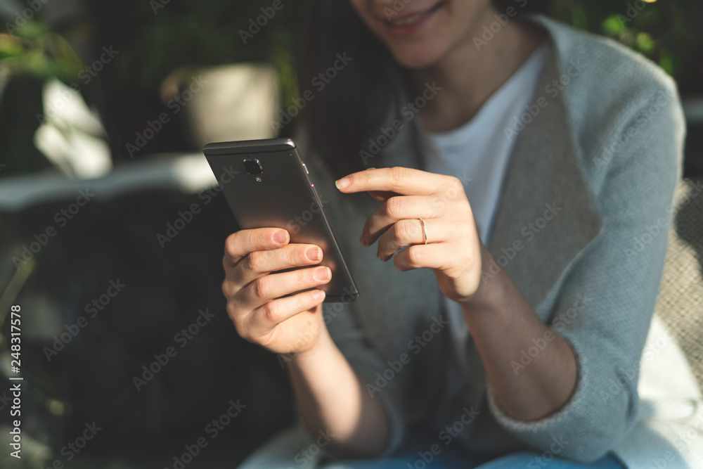 Woman holding cellular in her hands and pointing on display Woman holding cellular in her hands and pointing on display