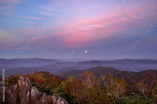 Hazy evening moonrise at sunset over unicoi mountains in North Carolina