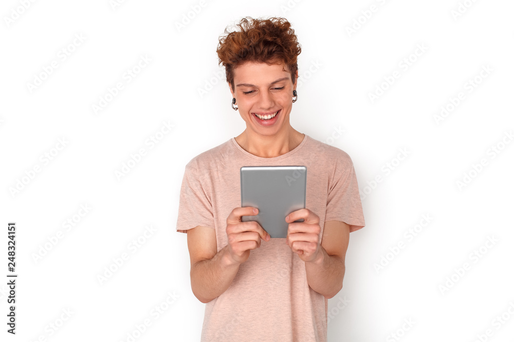 Teenager with earrings studio standing isolated on white video chat on digital tablet cheerful