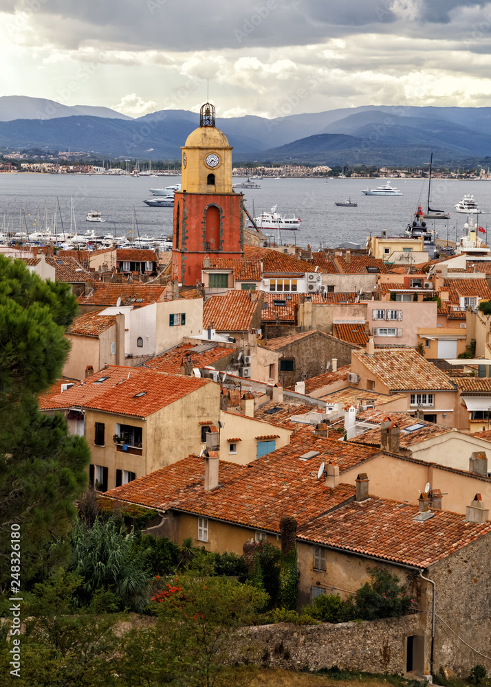 Fototapeta premium View to the rooftops and church tower of the old town of Saint Tropez, French Rivera, France. Vertical cityscape. Holidays in France.