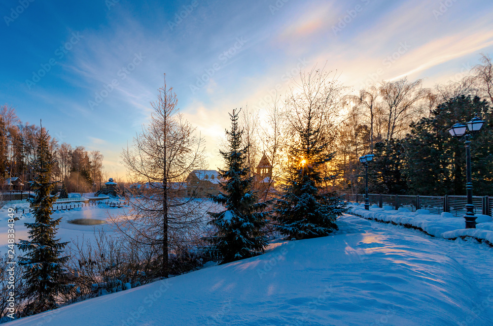 Fototapeta premium Sunrise over the snow-covered lake in the Park