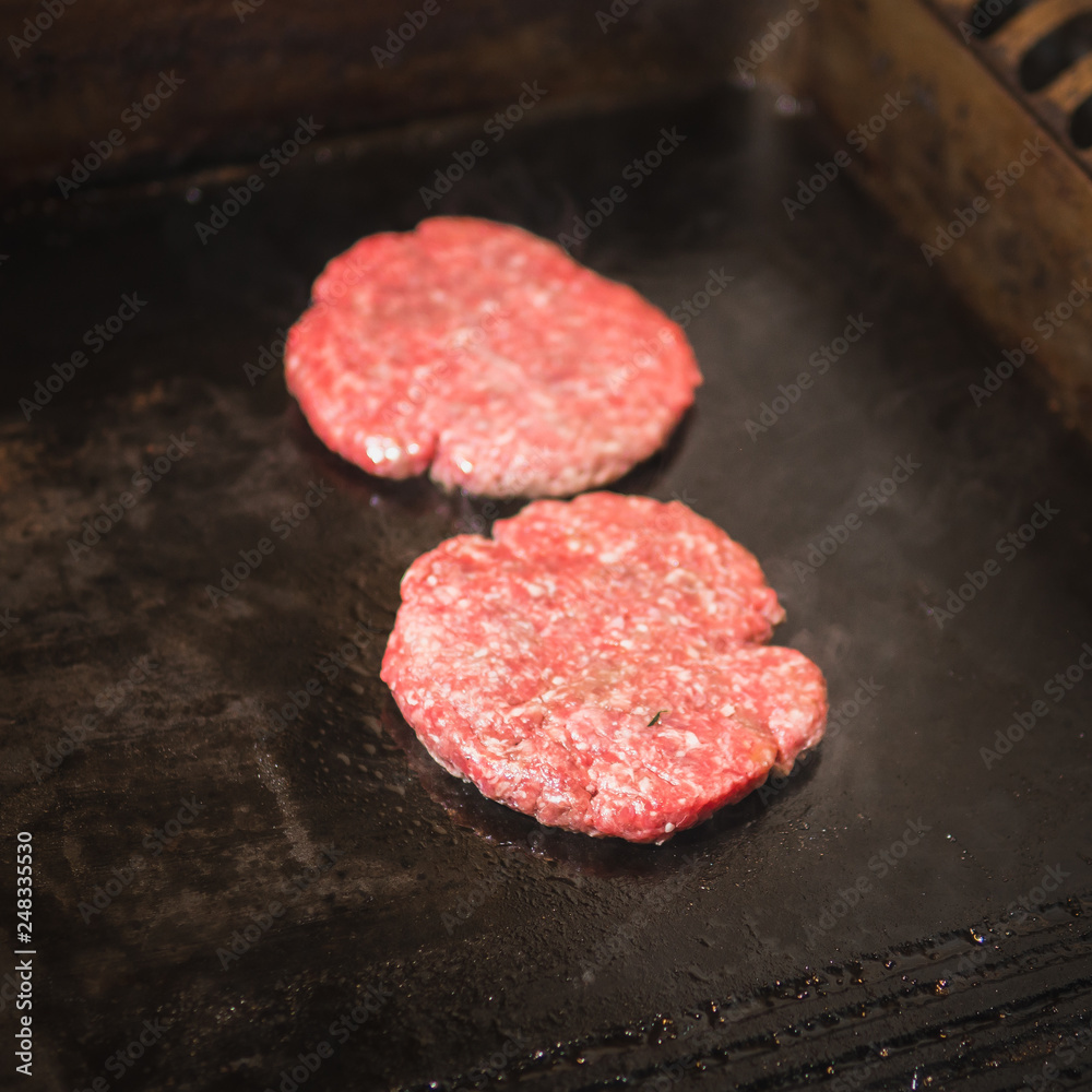 Burger on a stove background. Cooking delicious hamburger cheeseburger with bacon. Healthy fresh food hot heat for eating Burger on a stove background. Cooking delicious hamburger cheeseburger with bacon. Healthy fresh food hot heat for eating