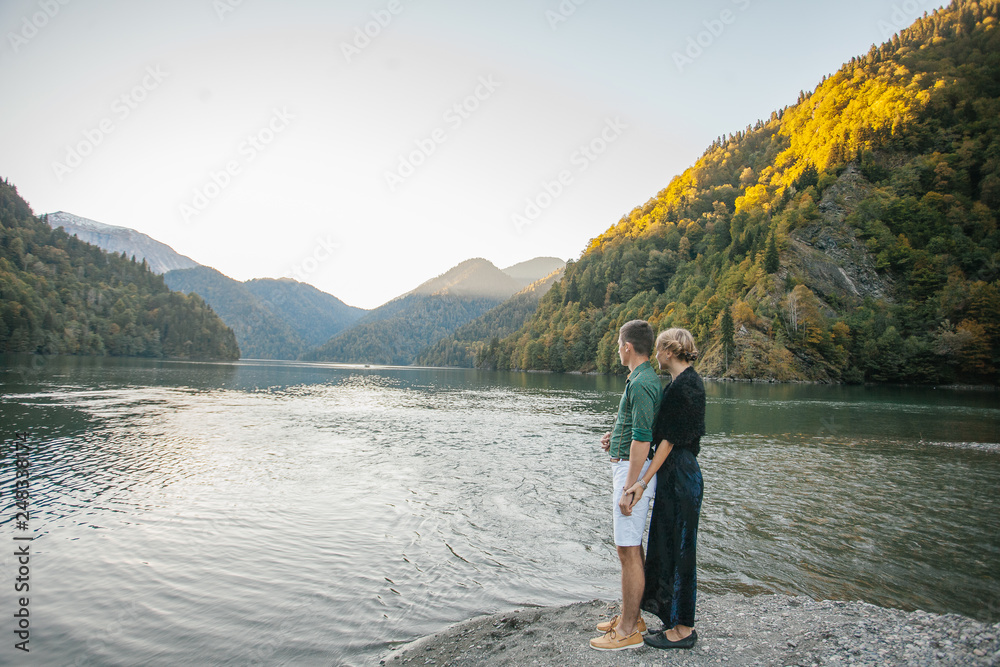 man and woman looking at lake