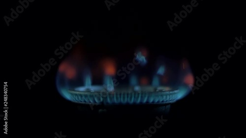 Beautiful blue flame of a gas stove in the kitchen in the dark. Dark Design photo