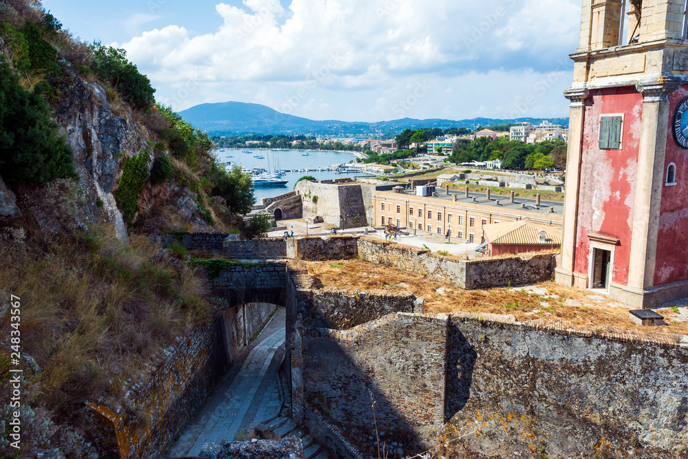 Abandoned clock tower in old fortress in Corfu with panoramic view of Corfu town, Greece.