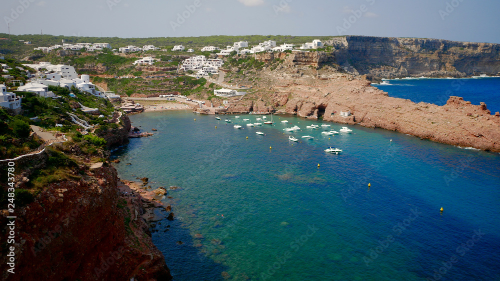 Beautifull view of Cala Morell cove, red rocks and clear blue water, Menorca island, Balearic Islands, Spain.