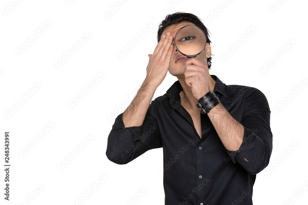 a man looks with one eye through a magnifying glass on an isolated Studio background a man looks with one eye through a magnifying glass on an isolated Studio background