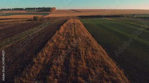 Aerial fly above autumn countryside field at sunrise - sunset, 4K