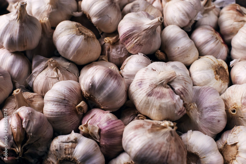 Vitamin healthy food spice image. Spicy cooking ingredient picture. White garlic pile texture. Fresh garlic market table closeup photo. Pile white garlic head heap top view.
