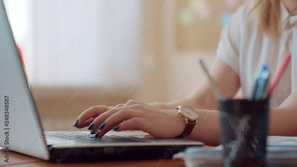 Girl in a white blouse close up typing on the laptop keyboard, on hand clock and manicure