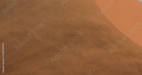 Red orange sand dune wave patterns with wind blowing sand over the dune, Sossusvlei, Namibia. Strong wind in the sand desert, pour. Landscape in Africa.