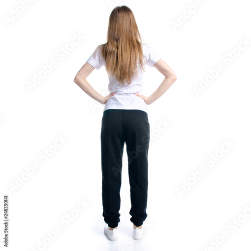 Woman in black sweatpants and white t-shirt standing on white background isolation, back view © Kabardins photo