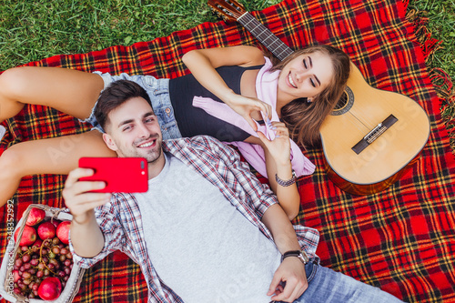 Attractive man with his girlfriend making selfie.They feeling love.Picnic day