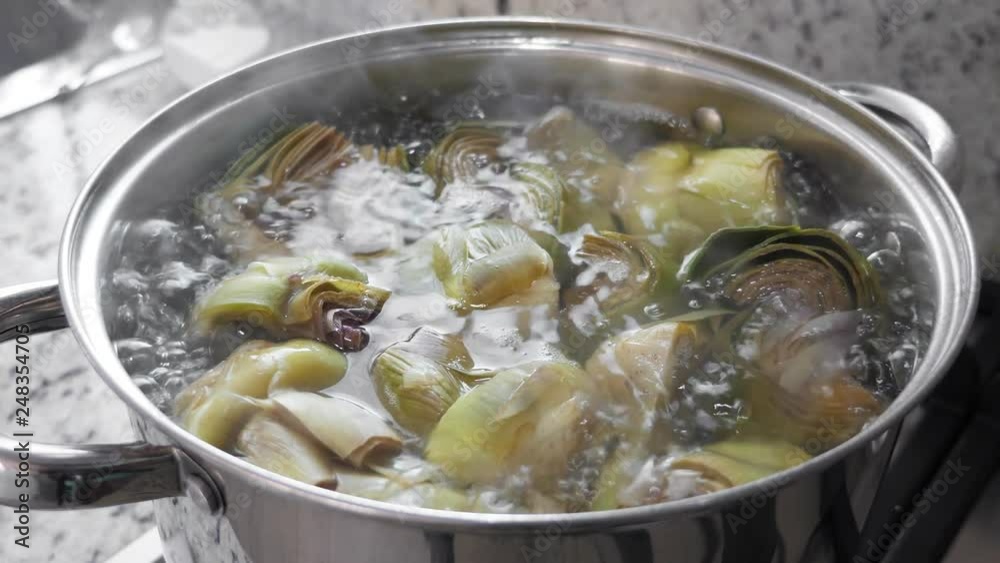 Boiling and cooking artichokes in saucepan, closeup Boiling and cooking artichokes in saucepan, closeup