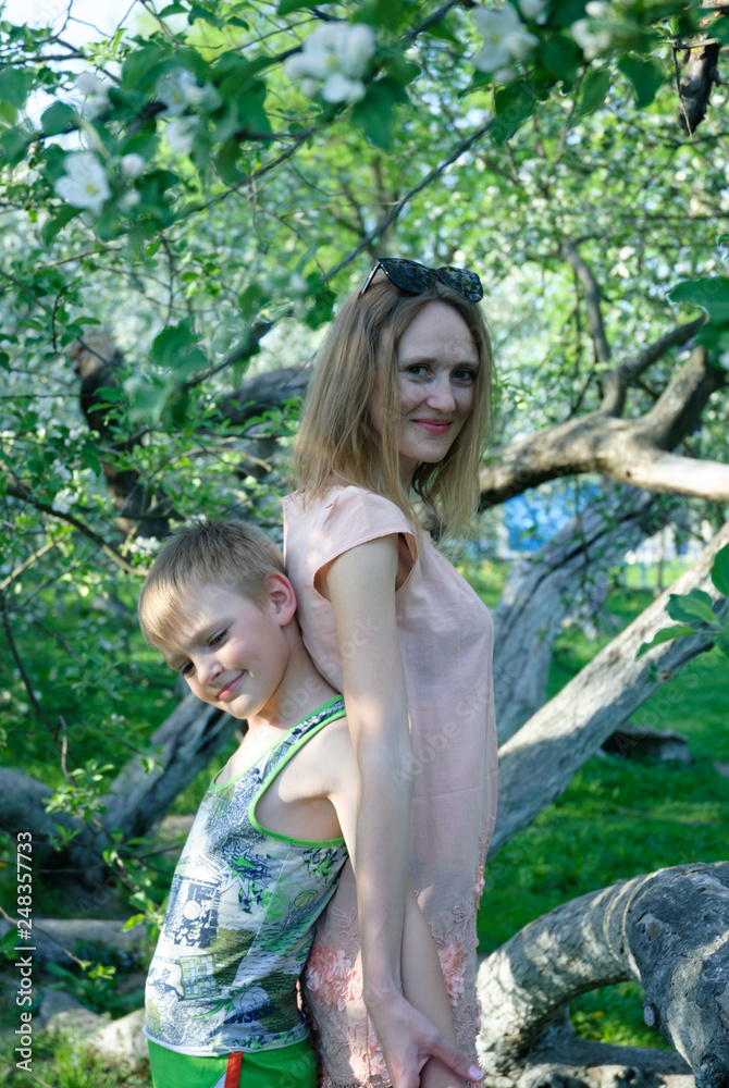 woman with child looking on the blossom tree woman with child looking on the blossom tree