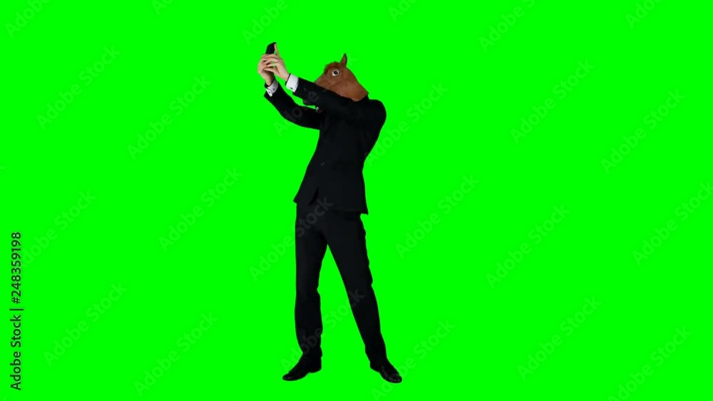 Hilarious Businessman in a Horse Mask Taking a Selfie on a Green Screen