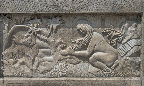 Stone relief panel showing tradional Chinese scene. Woman washing her hair in a stream.