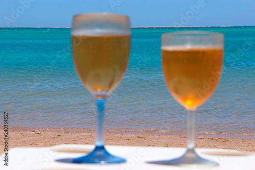 Two glasses of cold beer by sea. Chilled beer in glasses on table on seacoast