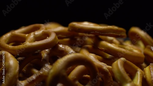 Pretzel salted in rotation. Close up. Studio shot. Black background. Unhealthy diet concept. Junk food concept.