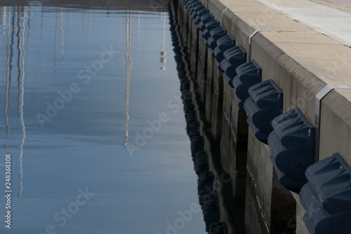 posti barca in banchina con respingenti blu su riflesso