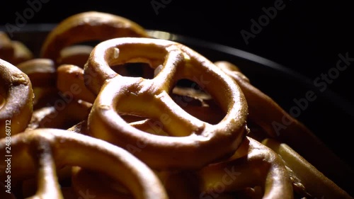 Pretzel salted in rotation. Close up. Studio shot. Black background. Unhealthy diet concept. Junk food concept.