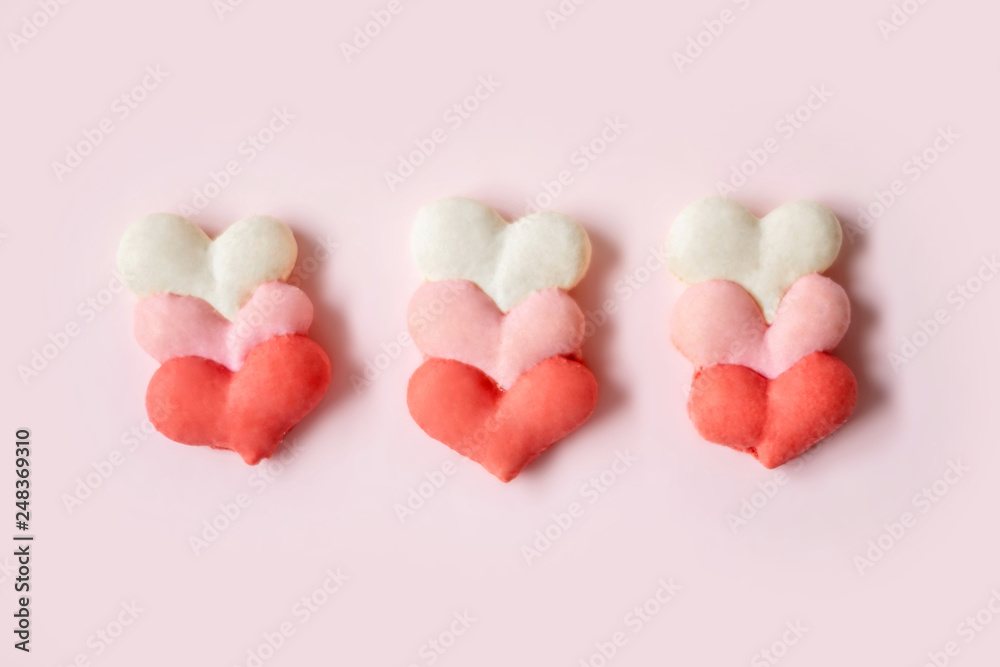 Heart shaped macarons on a pink background for Valentine's day