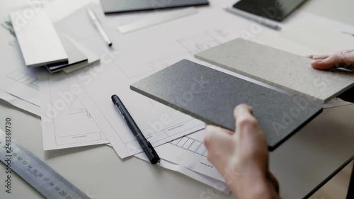 Woman fills data in graphs on paper. Records information. Woman is engaged in office work. Graphic charts,indicators. Woman works at the offside table. Woman draws symbols on the paper