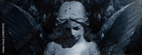 Angel of death. Retro styled ancient statue of sad angel as symbol of pain, fear and end of life. photo