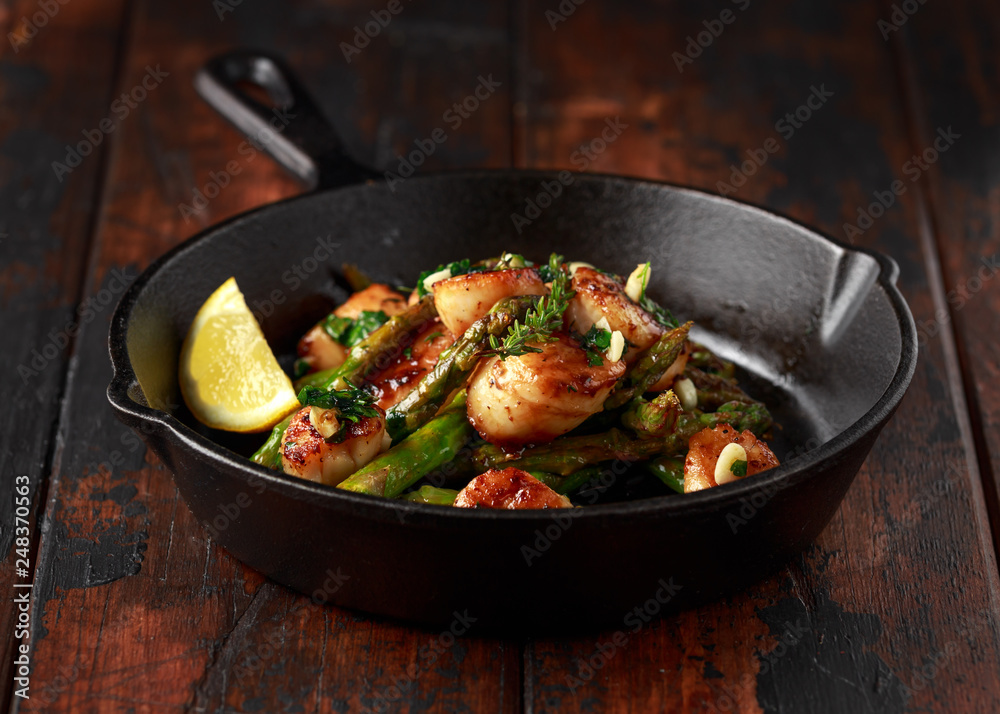 Scallops seared in garlic and parsley butter served in cast iron skillet Scallops seared in garlic and parsley butter served in cast iron skillet