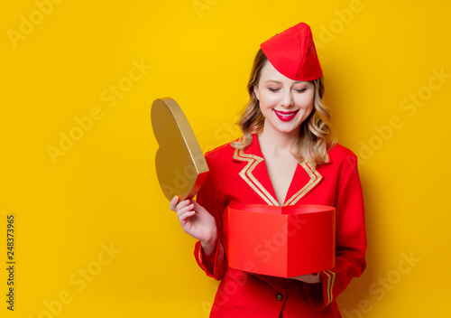 stewardess wearing in red uniform with heart shape holiday gfit box photo